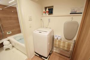 a small bathroom with a washing machine and a tub at FINOA Residential Suite Asakusa/Oshiage Skytree in Tokyo +52 photos