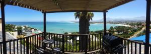 Un balcón con sillas y vista al mar. en Palm Tree Self-Catering Apartment, en Gordonʼs Bay