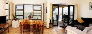 高登灣的住宿－Palm Tree Self-Catering Apartment，客厅配有桌椅和沙发