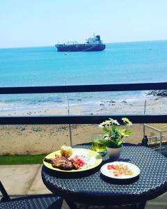 una mesa con dos platos de comida en la playa en Departamento vista al mar, en Ilo
