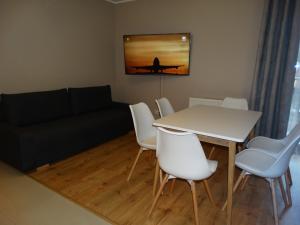 salon ze stołem, krzesłami i kanapą w obiekcie Apartamenty Miku w mieście Krynica Zdrój