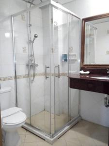 a bathroom with a shower with a toilet and a sink at Seaview Sriracha Hotel in Si Racha