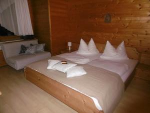 1 dormitorio con 1 cama grande con almohadas blancas en Appartements Oberhof, en Wagrain