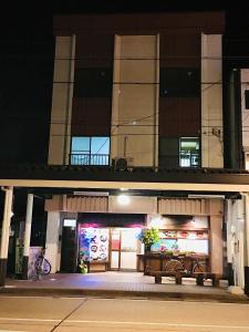 un bâtiment avec un banc devant lui la nuit dans l'établissement オイソ, à Iiyama