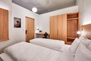 1 Schlafzimmer mit 2 weißen Betten und einem Schrank in der Unterkunft Hotel Walther v.d. Vogelweide Superior in Klausen