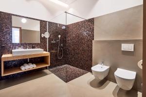 a bathroom with a toilet and a sink and a shower at Hotel Walther v.d. Vogelweide Superior in Chiusa
