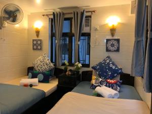 Habitación pequeña con 2 camas y ventana en Sydney Hostel, en Hong Kong