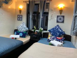 a bedroom with two beds with pillows and a mirror at Sydney Hostel in Hong Kong