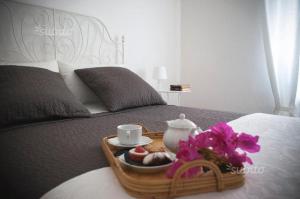 taca z jedzeniem i zestaw do parzenia herbaty na łóżku w obiekcie Villa la Rina w mieście Palermo