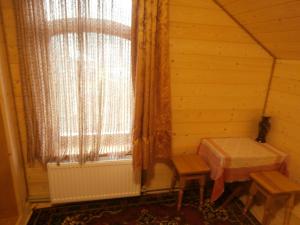 Zimmer mit einem Fenster mit einem Tisch und Bänken in der Unterkunft Karpatskiy Domik Izki in Izky
