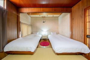 two beds in a small room with a room with at Bettei Rin 別邸 凛 in Kyoto