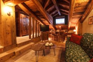 a living room with a couch and a table at Au Coeur Des Neiges Resort SPA & FREE E-BIKE in Courmayeur