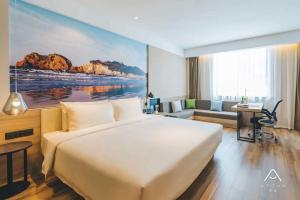 ein Hotelzimmer mit einem großen Bett und einem Schreibtisch in der Unterkunft Atour Hotel Ningbo Airport Yinzhou Avenue in Ningbo