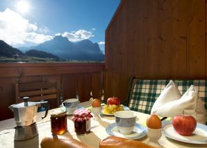 a table with food and fruit on it with a view at Appartements Plattnerhof in Castelrotto