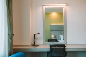 biurko z lustrem i krzesłem w pokoju w obiekcie Ritz Grand Hotel Mandalay w mieście Mandalaj