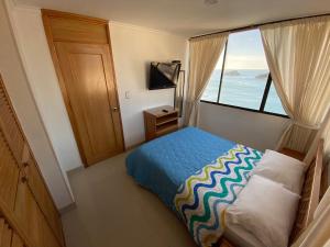 a bedroom with a bed and a large window at Rivas Apartamentos Santa Marta in Santa Marta
