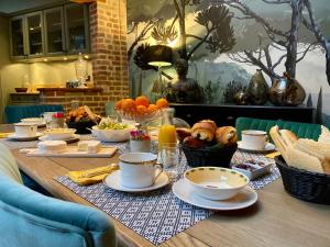 a wooden table with breakfast foods and drinks on it at VILLA DU CEDRE Honfleur in Honfleur