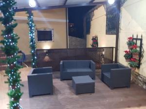 a lobby with blue chairs and a television and christmas decorations at Toño el Alguacil in Selaya