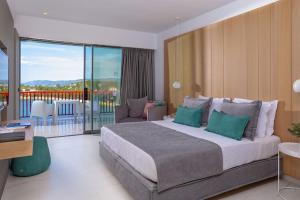 a bedroom with a large bed and a balcony at Skiathos Palace Hotel in Koukounaries