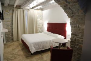a bedroom with a bed and a table in a room at Montis Country & Charme in San Massimo