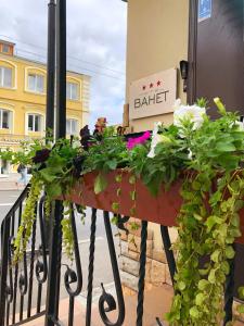 un balcón con flores y una señal en un edificio en Hotel Bahet, en Kazán