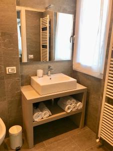 a bathroom with a sink and a mirror and towels at B&B Penak Mountain wellness in Aprica