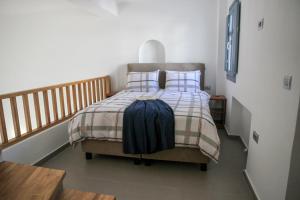 una camera da letto con un letto con una coperta e cuscini di Luxe Maroussi Villas a Pyrgos