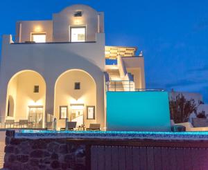 un grande edificio bianco con una luce blu davanti di Luxe Maroussi Villas a Pyrgos