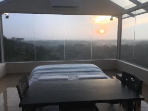 een slaapkamer met een bed voor een groot raam bij Sky Retreat - Sri Lanka in Gampaha