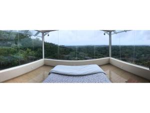 - une chambre avec un lit et de grandes fenêtres dans l'établissement Sky Retreat - Sri Lanka, à Gampaha