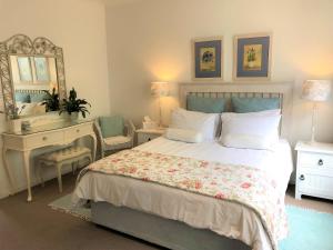 a bedroom with a bed and a vanity and a mirror at Cherry Berry Guest House in George