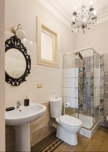 a bathroom with a toilet and a sink and a mirror at Palazzo Arcidiacono - luxury holidays in Catania