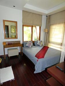 a bedroom with a bed with a desk and a mirror at The Beach Condo in Ko Chang