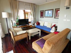 a living room with a couch and a tv at The Beach Condo in Ko Chang