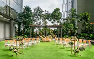 a set up for a wedding in a building with tables and chairs at Oasia Hotel Downtown, Singapore by Far East Hospitality in Singapore
