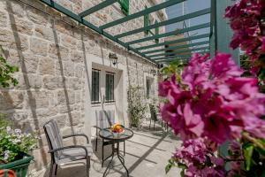 a patio with a table and chairs and flowers at Conborgo Apartments in Kumbor