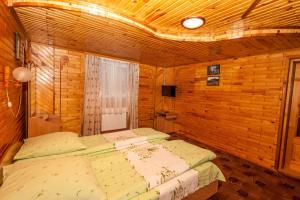 a bedroom with two beds in a wooden room at Smerekova Hata in Yablunytsya