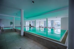 a swimming pool in a building with blue lighting at Feriendomizil Binz in Binz