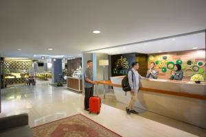 a group of people standing in a store with a suitcase at KHAS Malioboro Hotel in Yogyakarta
