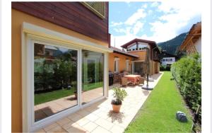 patio z przesuwnymi szklanymi drzwiami na domu w obiekcie Alpine Escape Holiday Home with Mountain View w Garmisch Partenkirchen