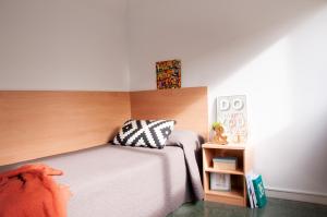 a bedroom with a bed with a wooden headboard at Residencia Tomás Alfaro Fournier in Vitoria-Gasteiz