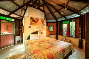 una camera da letto con un letto in una stanza con finestre di Cocoa Cottage a Roseau