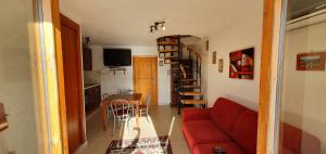 sala de estar con sofá rojo y mesa en Appartamento in una valle di Luce en Pizzoferrato