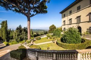 um grande edifício com uma árvore no quintal em Borgo Bucciano em San Miniato