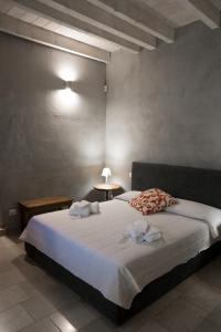 1 dormitorio con 1 cama grande y toallas. en Graffiti B&B Apartments, en Corato