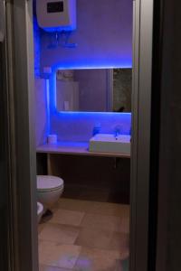 baño con lavabo y aseo con luz azul en Graffiti B&B Apartments, en Corato