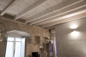 Cette chambre est dotée d'un mur en pierre et d'une fenêtre. dans l'établissement Graffiti B&B Apartments, à Corato