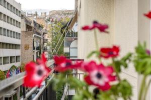 un gruppo di fiori rossi su un balcone di Acropolis Now! 2BR in central Athens ad Atene