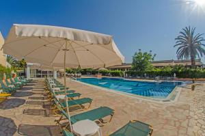 a swimming pool with chairs and a large umbrella at Takis Apartments in Sidari +9 photos