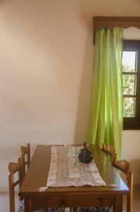 a dining room table with a green curtain at Takis Apartments in Sidari